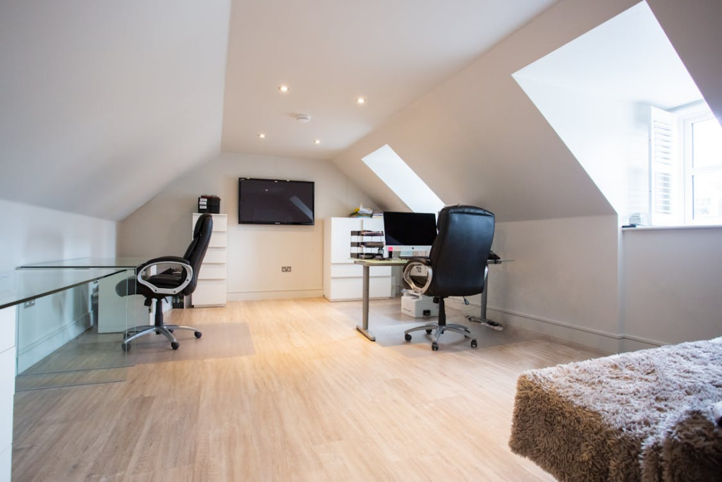 attic conversion ideas showing renovated attic home office with skylights and sloped ceilings