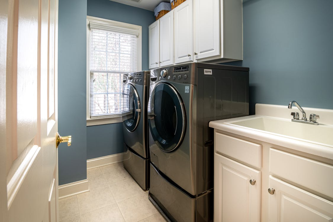 laundry room remodel ideas featuring modern washer dryer layout with storage cabinets and utility sink